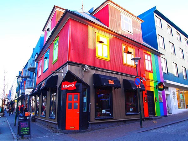 The outside of a bar with brightly colored walls.