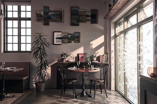 An interior picture of a restaurant with an empty table set with two wine glasses.