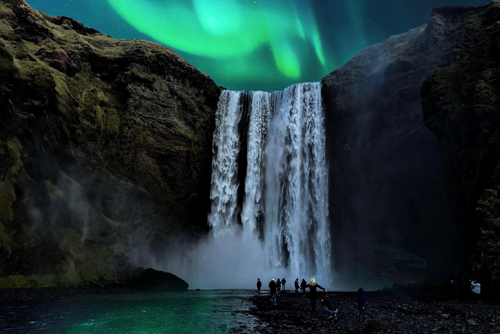 A large waterfall at night, with the Aurora Borealis shining above it.