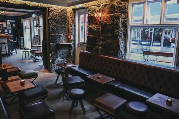 The inside of a bar with empty tables.